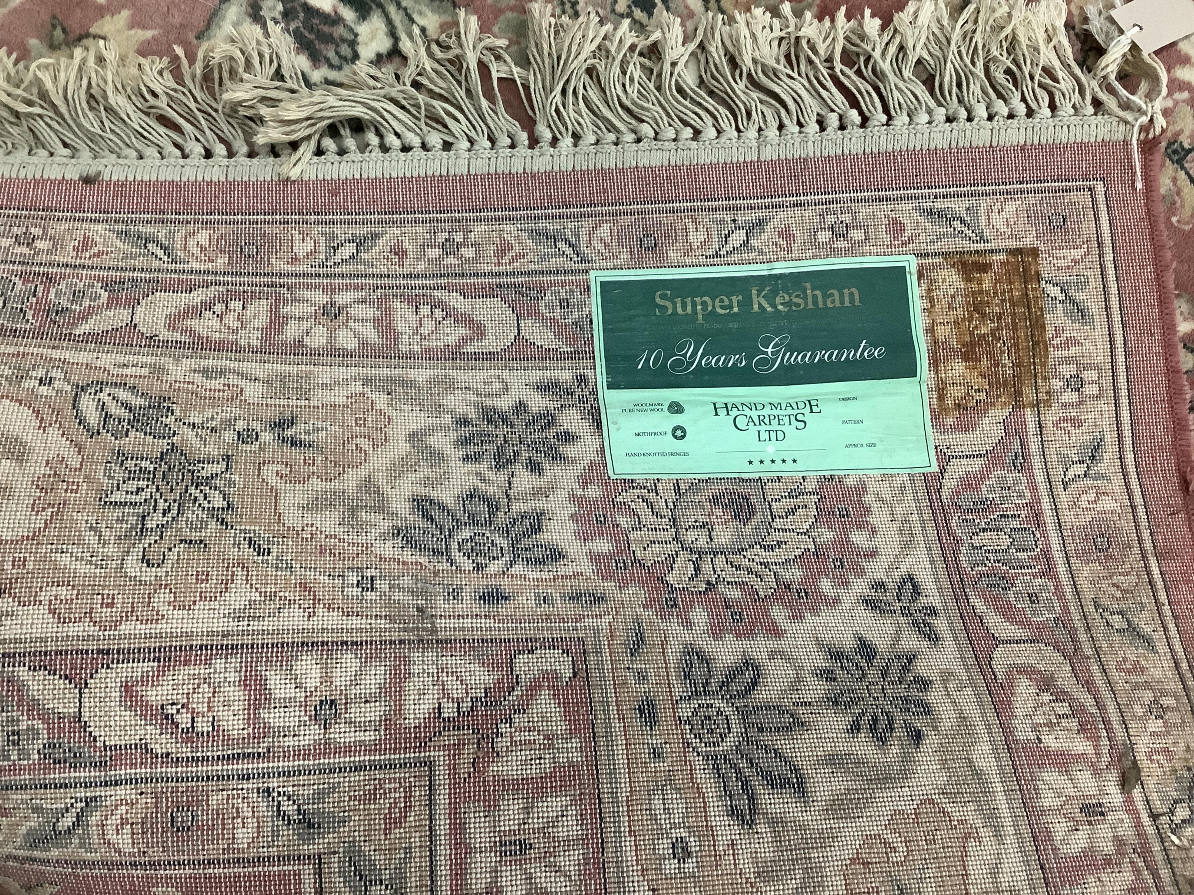 A Kashan style peach ground machined carpet, 360 x 274cm. Condition - fair to good, will require cleaning.